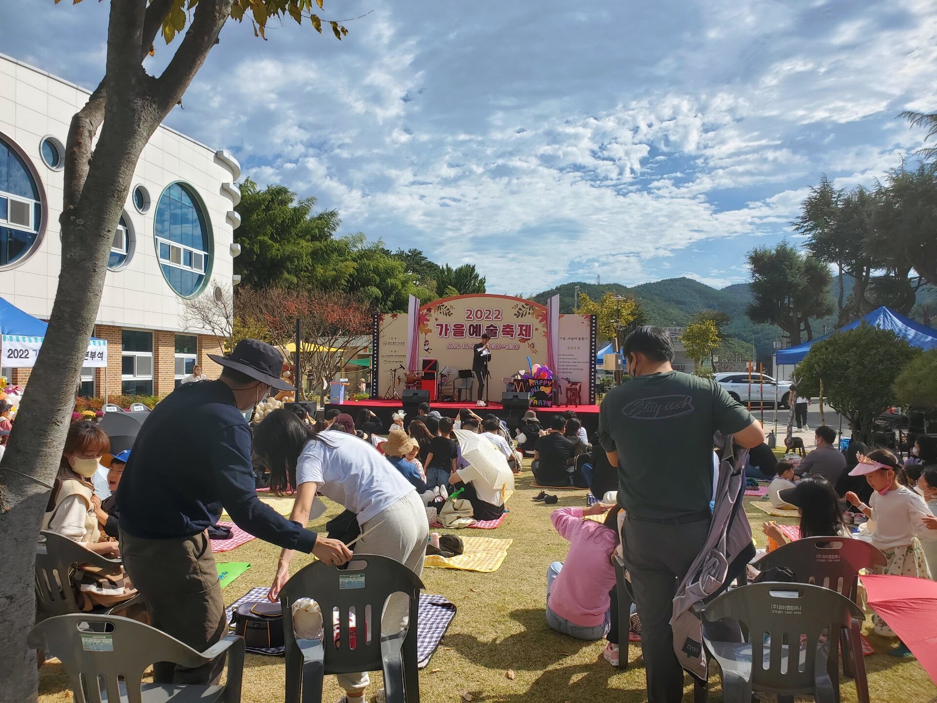 잔디마당에 관객이 자리한 지역 문화축제 전경
